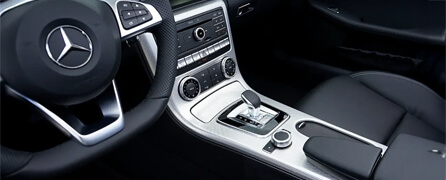 Interior de un auto de lujo Mercedes-Benz, con vista de la consola central y el volante