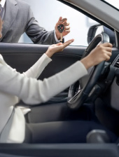 Banner sobre documentos y requisitos para comprar carro usado en Colombia, mostrando la entrega de llaves a una conductora.